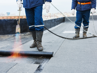 commercial roofers working on flat roof commercial building