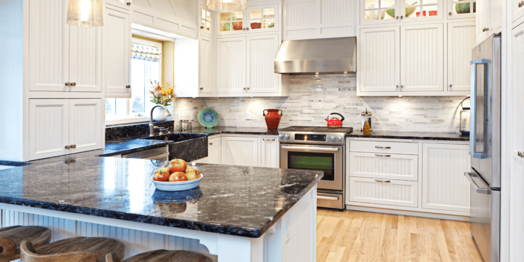 new kitchen with white cabinets and black counter tops
