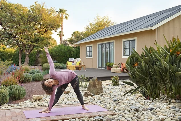 woman doing yoga outside home with solar shingles